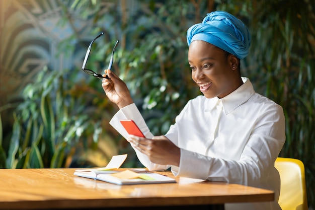 Emotional black woman reading emails on smartphone copy space