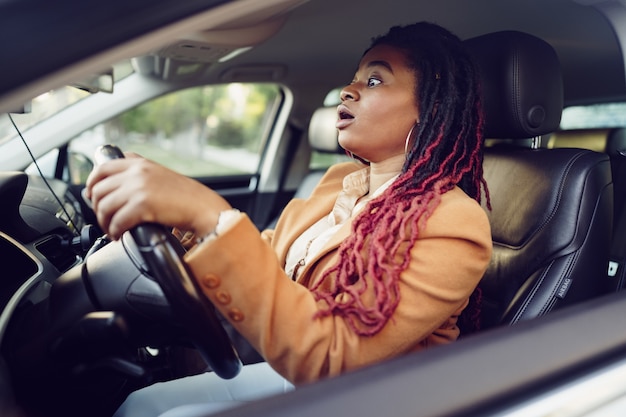 Emotional black woman sitting in a car