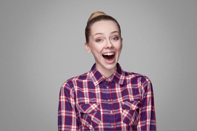 Emotional blonde girl on gray background