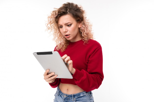 Emotional caucasian girl with curly fair hair chatting with friends and is surprised