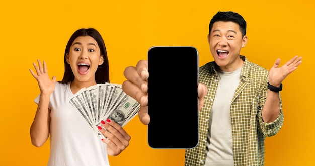 Emotional chinese man and woman trading on stocks using smartphone