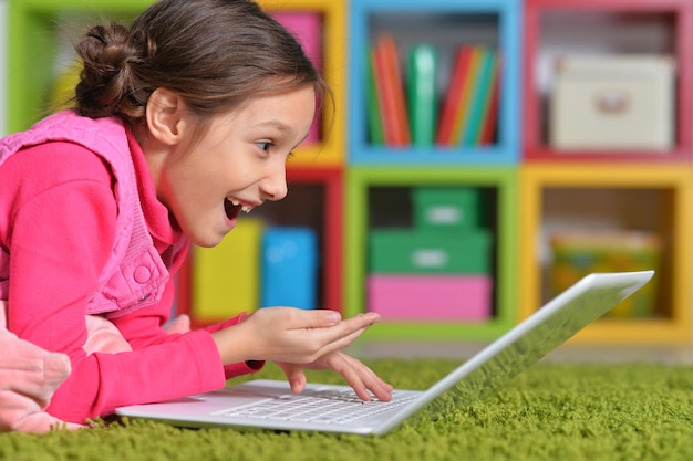 Emotional cute girl using laptop