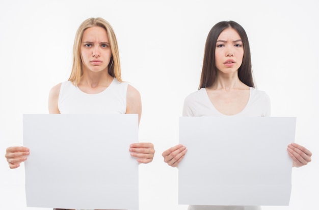 Emotional and disturbed young women. Each holds square pieces of paper.