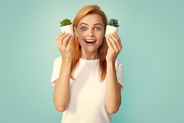 Emotional funny cute woman girl with a small cactus Closeup face portrait isolated on blue background