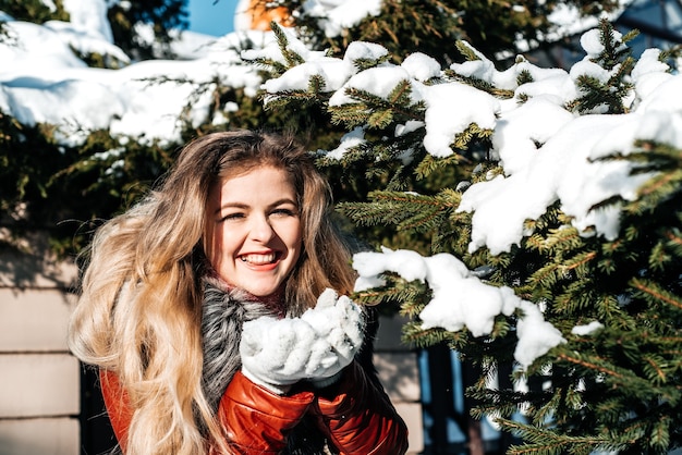 Emotional girl blowing snow in her hands