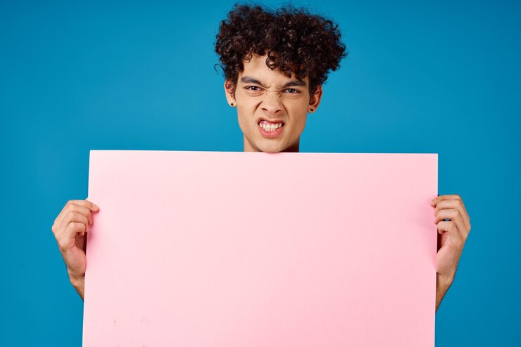 Photo emotional guy with pink poster mockup blue background high quality photo