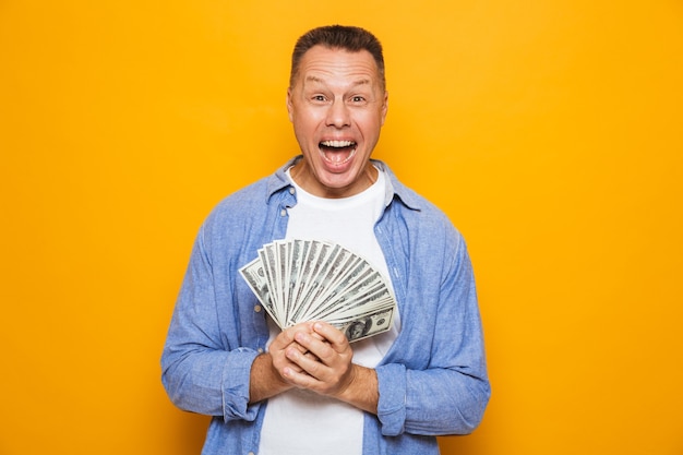 Emotional handsome man holding money.