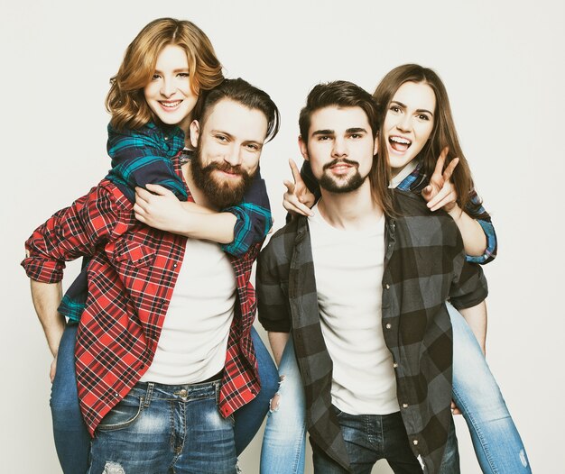 Emotional, happiness and people concept: Group Of Young People Giving Piggybacks over white background.Special Fashionable toning photos.