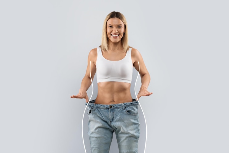 Photo 灰色の背景上の大きなジーンズで感情的な幸せな女
