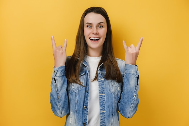 emotional happy woman shows rock n roll gesture