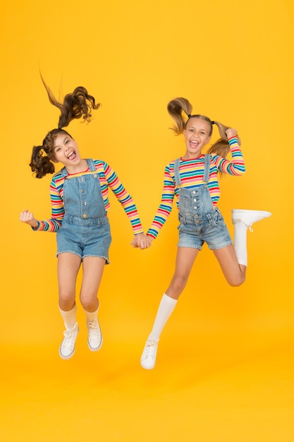 Emotional kids. Fashion shop. Must have accessory. Modern fashion. Kids fashion. Girls long hair. Cute children same outfits. Trendy and fancy. Little girls wearing rainbow clothes. Happiness.