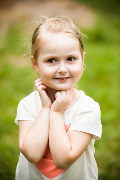 Emotional little blonde girl portrait in the park