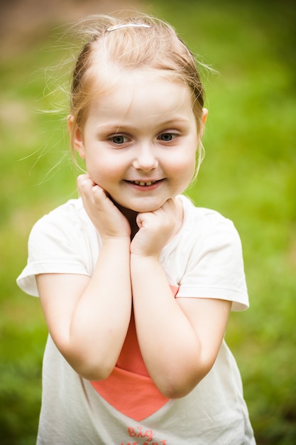 Emotional little blonde girl portrait in the park