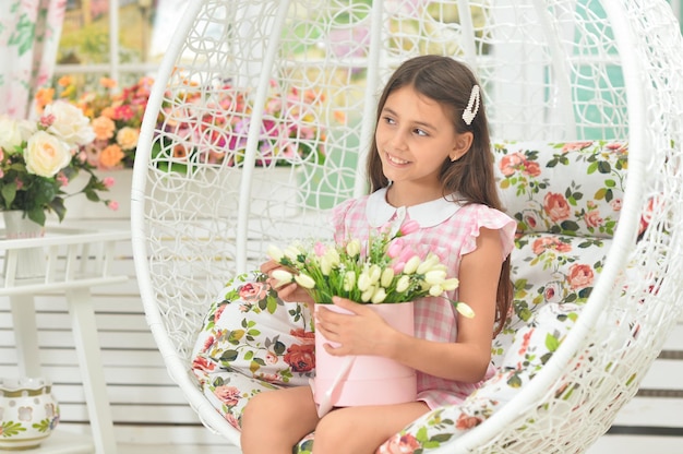 Emotional little girl in dress posing with flowers