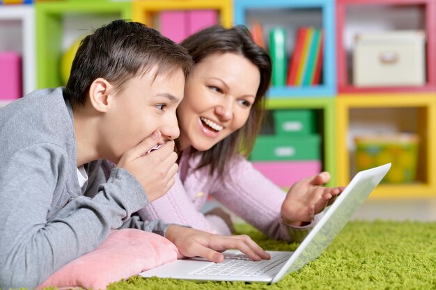 Emotional mother and son using modern laptop