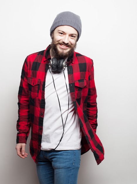 Emotional and people concept: young bearded man wearing hat with headphones