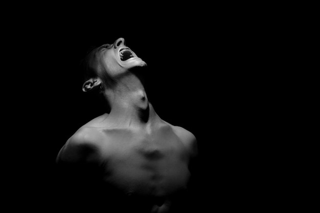 Emotional photo, man shouting on black background