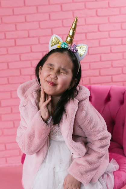 emotional portrait of asian girl in halloween costumes on pink background