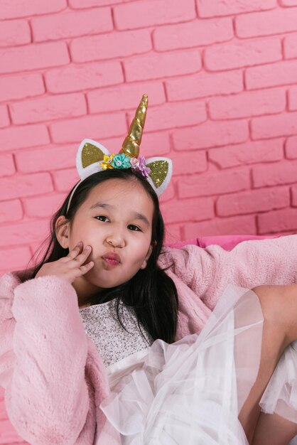 emotional portrait of asian girl in halloween costumes on pink background