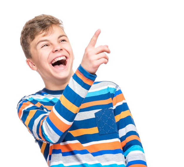 Emotional portrait of caucasian teen boy Funny teenager pointing and looking upwards while laughing isolated on white background Handsome happy child pointing at copy space