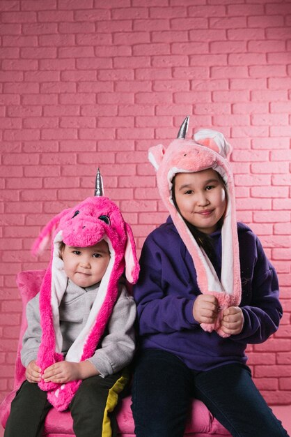 Ritratto emotivo di due ragazze asiatiche in costumi di halloween su sfondo rosa