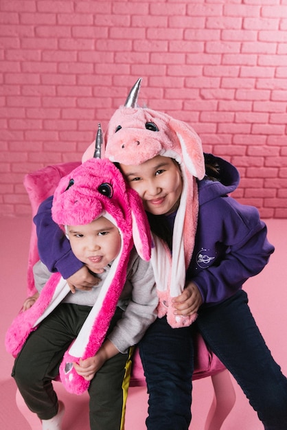 emotional portrait of two asian girls in halloween costumes on pink background