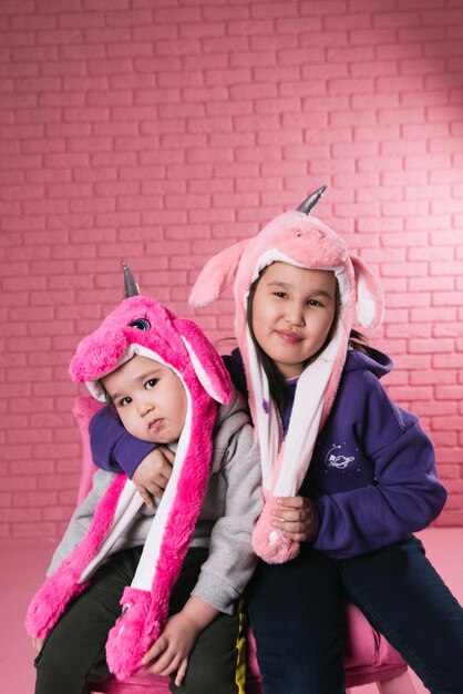 emotional portrait of two asian girls in halloween costumes on pink background