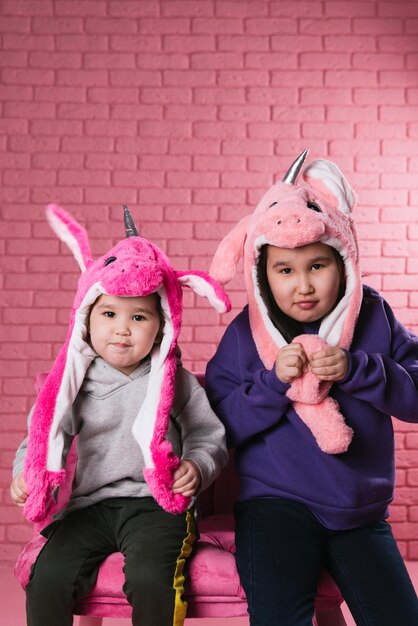 emotional portrait of two asian girls in halloween costumes on pink background