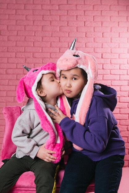 emotional portrait of two asian girls in halloween costumes on pink background