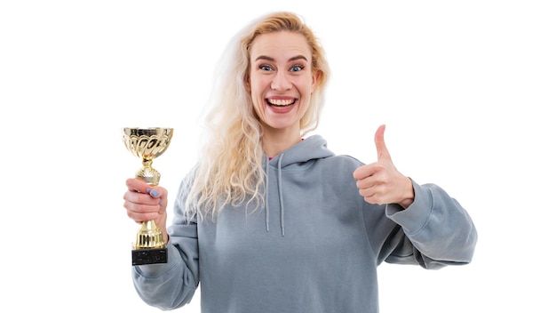 Photo emotional portrait of a young woman with a gold cup in her hands on a white background