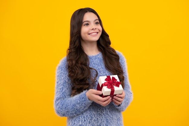 Emotional teenager child hold gift on birthday funny kid girl\
holding gift boxes celebrating happy new year or christmas happy\
teenager positive and smiling emotions of teen girl