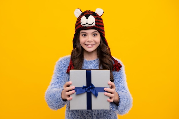 Emotional teenager child hold gift on birthday Funny kid girl holding gift boxes celebrating happy New Year or Christmas Happy teenager positive and smiling emotions of teen girl