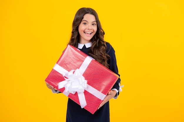 Emotional teenager child hold gift on birthday funny kid girl\
holding gift boxes celebrating happy new year or christmas