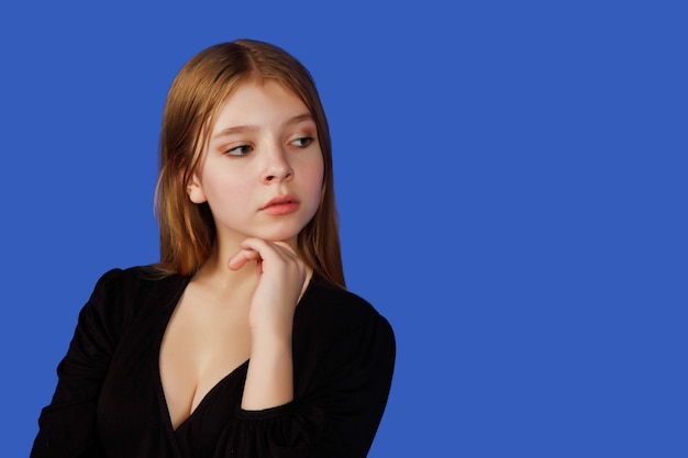Фото Эмоциональная тринадцатилетняя милая девочка-подросток думает и смотрит в сторону