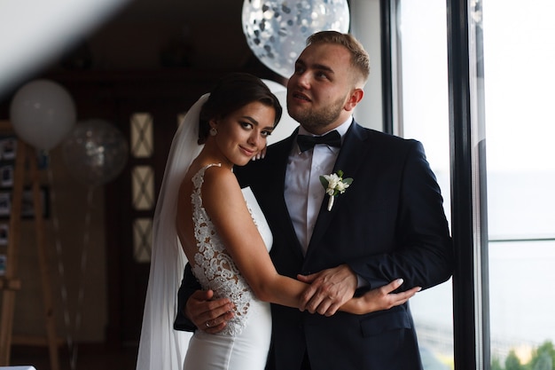 emotional wedding couple with balloons indoor