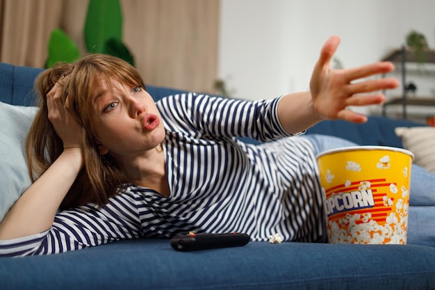 Emotional woman angry scream while watching tv in home