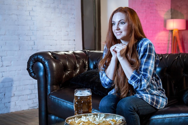 Emotional woman football fan at home sofa couch watching excited