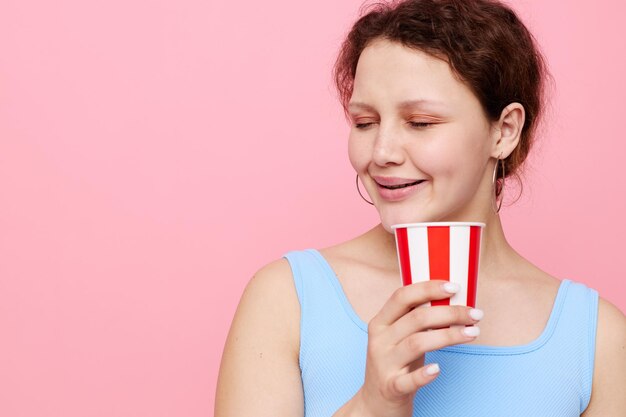 Emotional woman from disposable glasses drink pink background