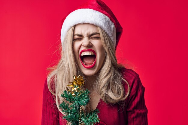 Emotional woman in santa costume fashion christmas tree with holiday toys