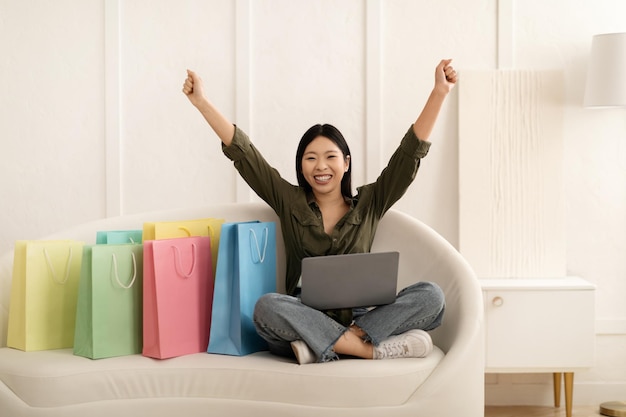 Emotional young asian woman shopaholic shopping from home