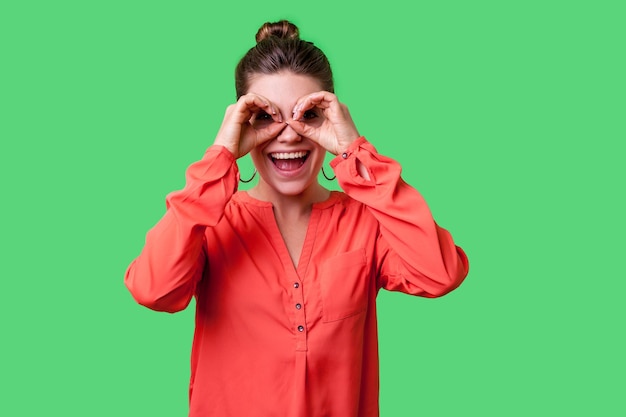 Emotional young brunette woman on green background