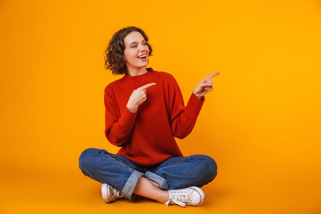 emotional young pretty woman posing isolated on yellow wall showing copyspace.