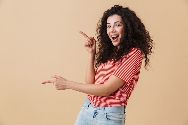 Emotional young woman isolated over beige wall