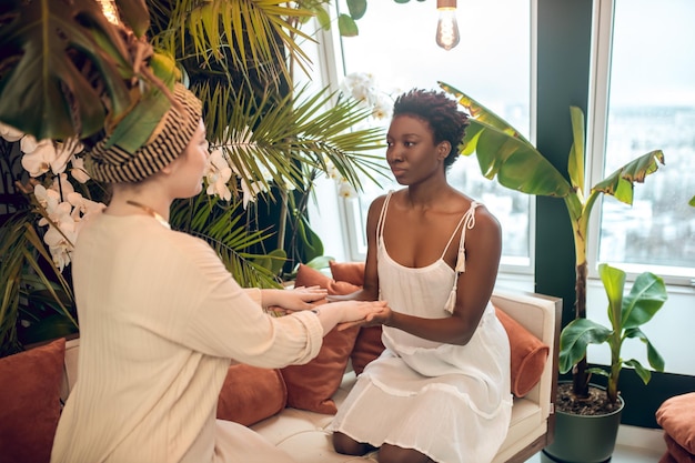 Emotionally burned dark-skinned woman having a healing session