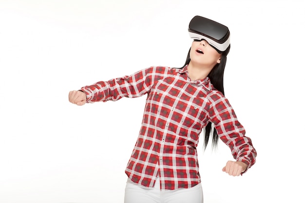 Photo emotionally girl in headset of vr gesturing and playing game.