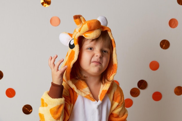 Emotioneel meisje in girafkostuum op witte achtergrond halloween-feestviering