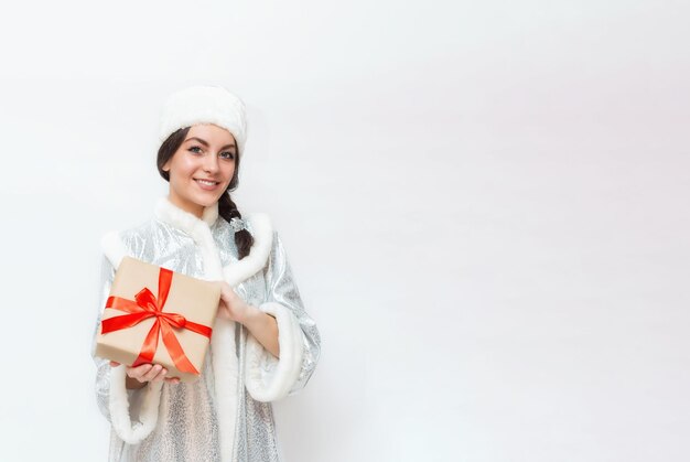 Foto emotioneel portret van een mooi donkerbruin meisje met een geschenkdoos in haar handen