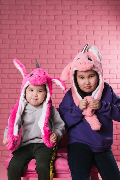 emotioneel portret van twee Aziatische meisjes in Halloween-kostuums op roze achtergrond