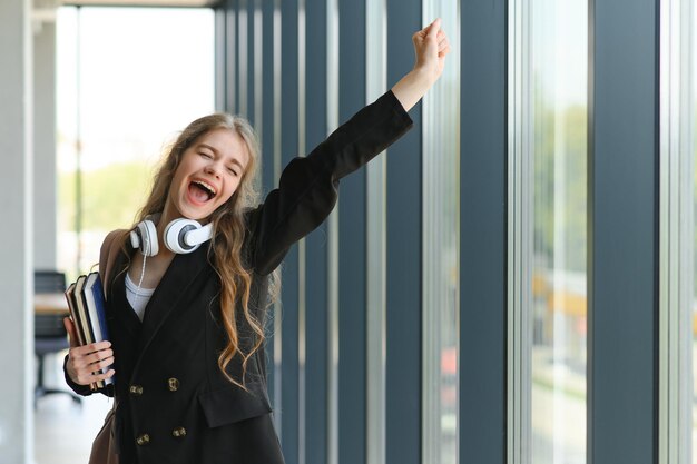 Emotioneel student meisje binnen de muren van het instituut viert succesvol examen geslaagd middelbare school of universiteit toelating Europese werknemer met opgeheven handen voelt zich gelukkig door salarisgroei werd gepromoveerd concept