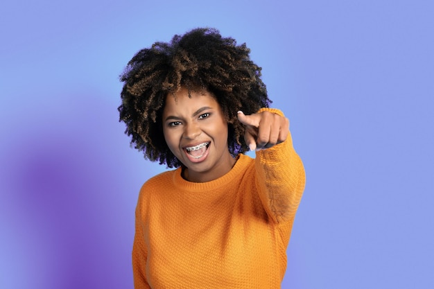 Emotionele hyperzwarte vrouw die naar de camera wijst